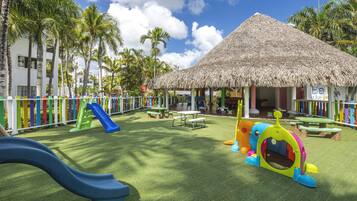 Children can play and explore in this vibrant outdoor play area featuring a slide, climbing frame, and colorful playhouse.
