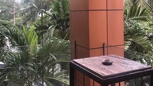 A balcony with a table and chairs, surrounded by lush tropical plants. - The Fusion Suites (Bangkok)