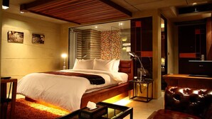 A modern hotel room with a large bed, a desk, a leather armchair, and a TV. - The Fusion Suites (Bangkok)