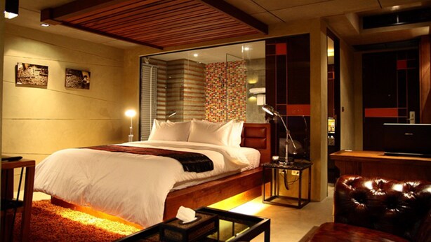 A modern hotel room with a large bed, a desk, a leather armchair, and a TV. - The Fusion Suites (Bangkok)