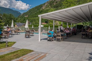 Una piscina al aire libre de temporada, sombrillas, tumbonas