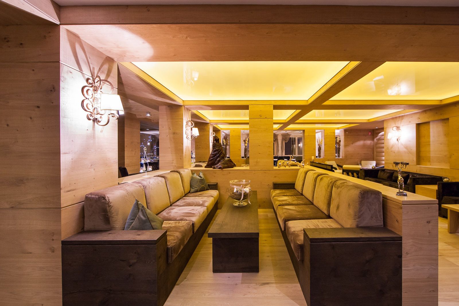 A spacious lounge area with multiple seating options, a central coffee table, and a view of the cityscape through large windows.