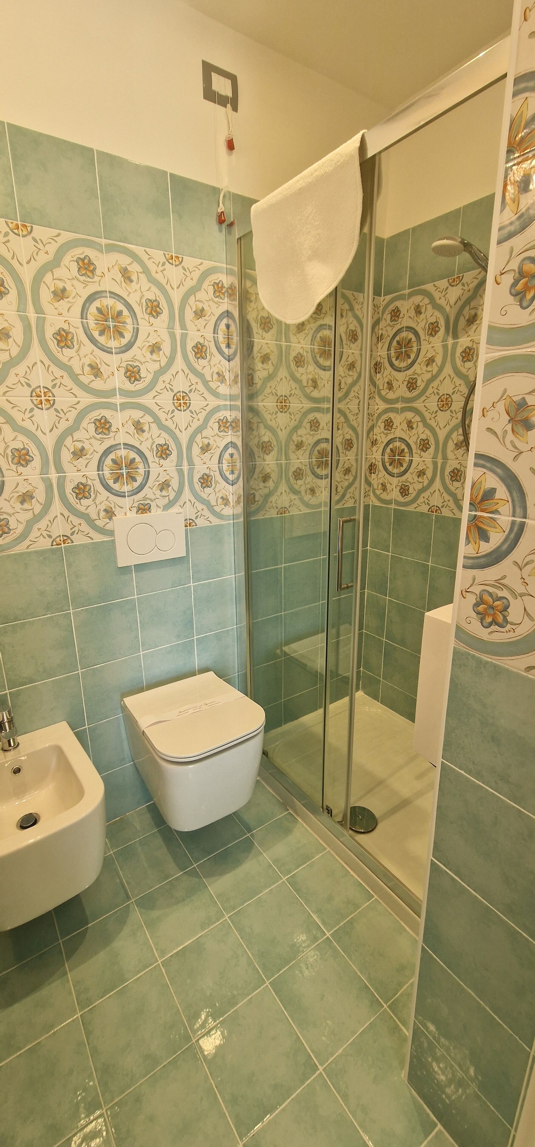 A bathroom with a shower, a toilet, and a sink.