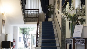 Un magnifique escalier menant à l’étage supérieur, agrémenté d’une décoration élégante et offrant une vue sur l’extérieur.