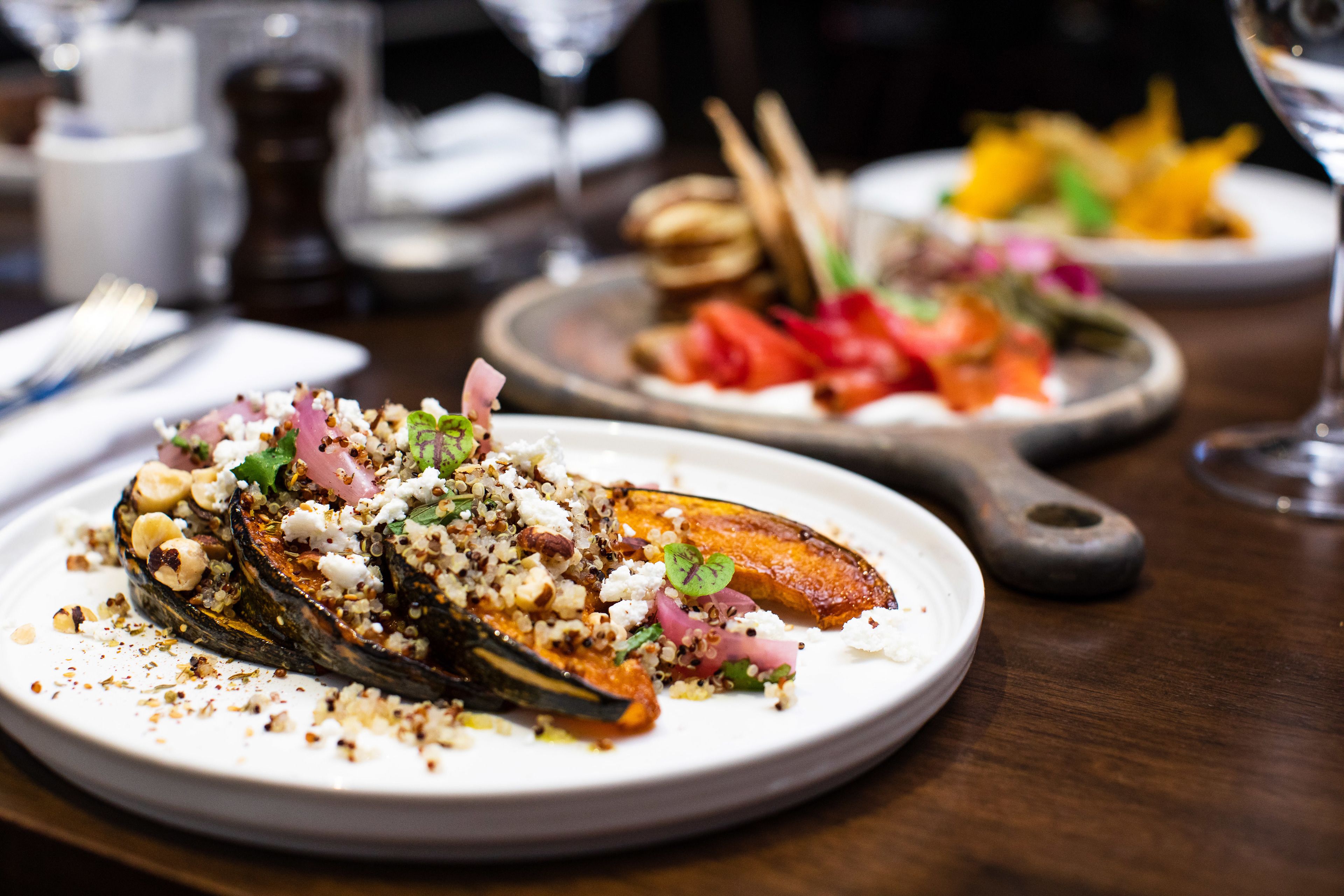 A dining table with plates of food, including a stuffed eggplant dish.