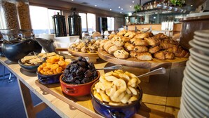 A buffet with various food items including pastries, fruits, and nuts.