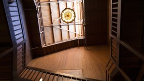 A wooden interior with a spiral staircase, a wooden floor, and a central light fixture.