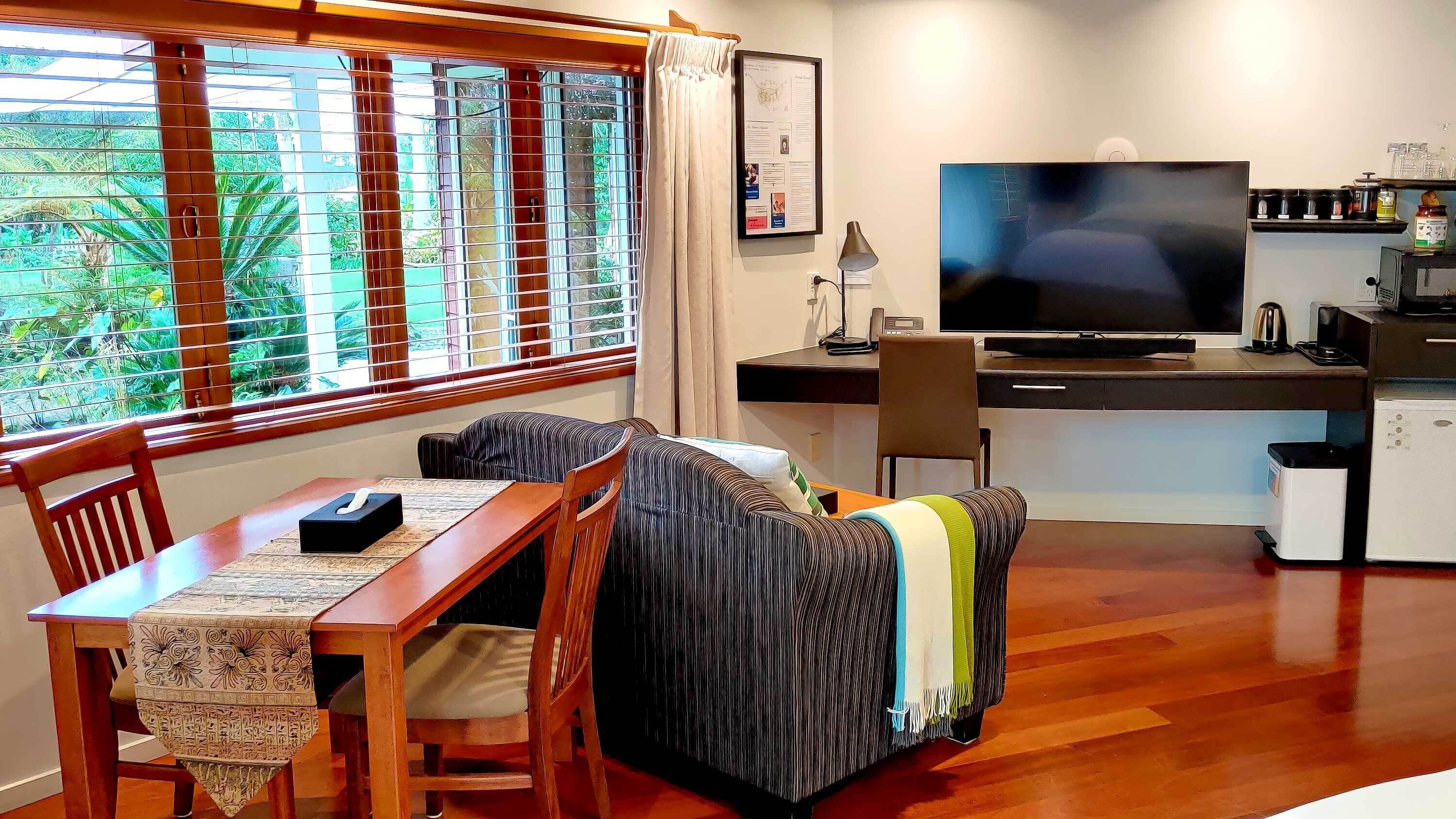 A compact living space with a dining table, sofa, and a TV.