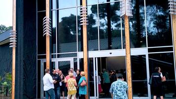 A modern building with large glass windows and wooden columns.