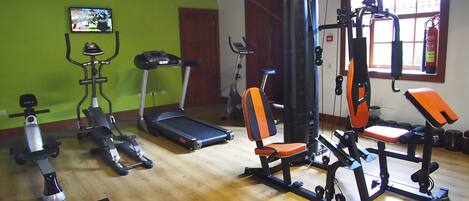 A gym with various exercise equipment including treadmills, weight machines, and a stationary bike.