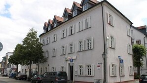 A two-story building with white shutters and a sign indicating a parking area. - Hotel Zum Löwen (Bad Homburg v.d. Hoehe)