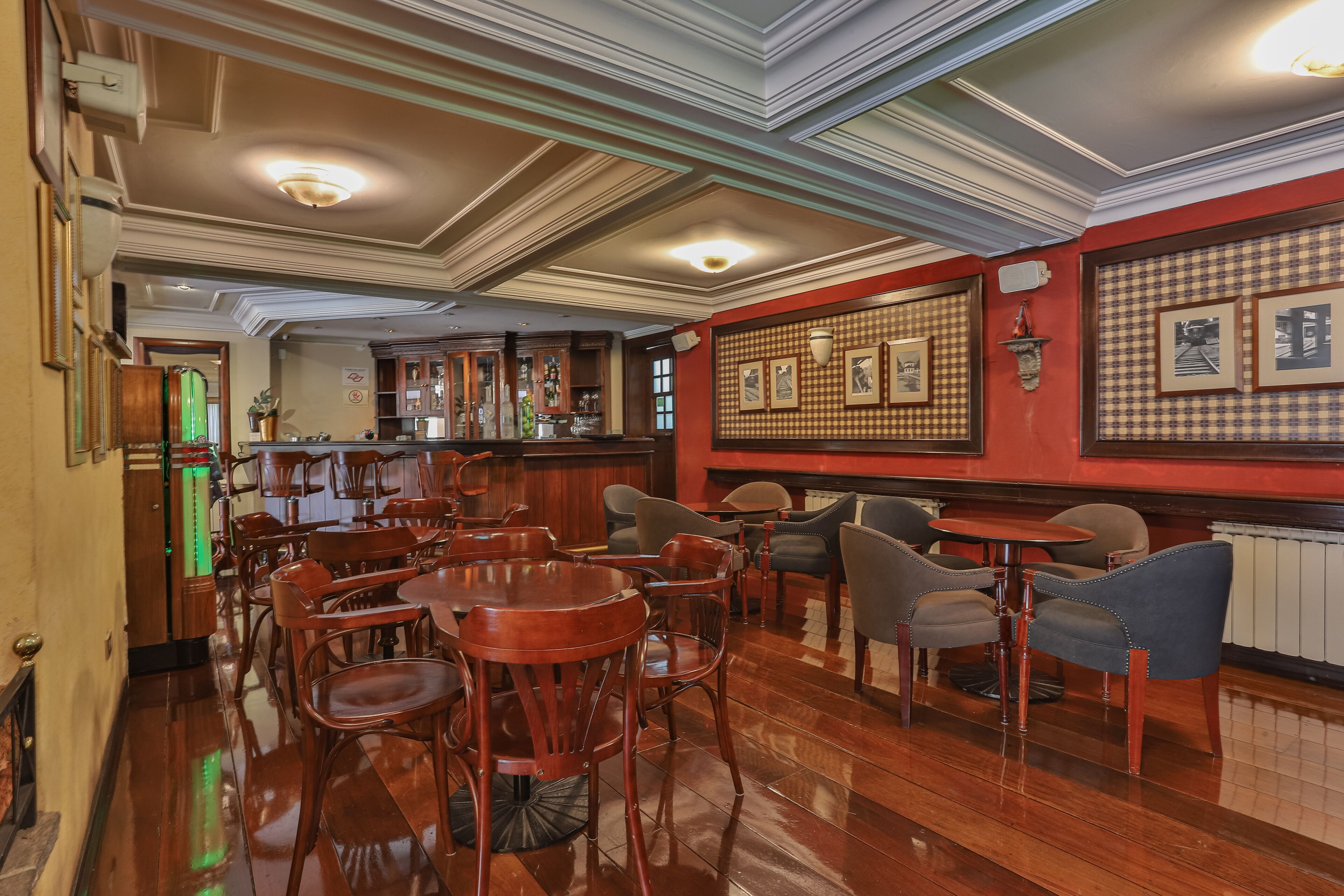 A bar area with wooden furniture, a checkered wall pattern, and a bar counter.