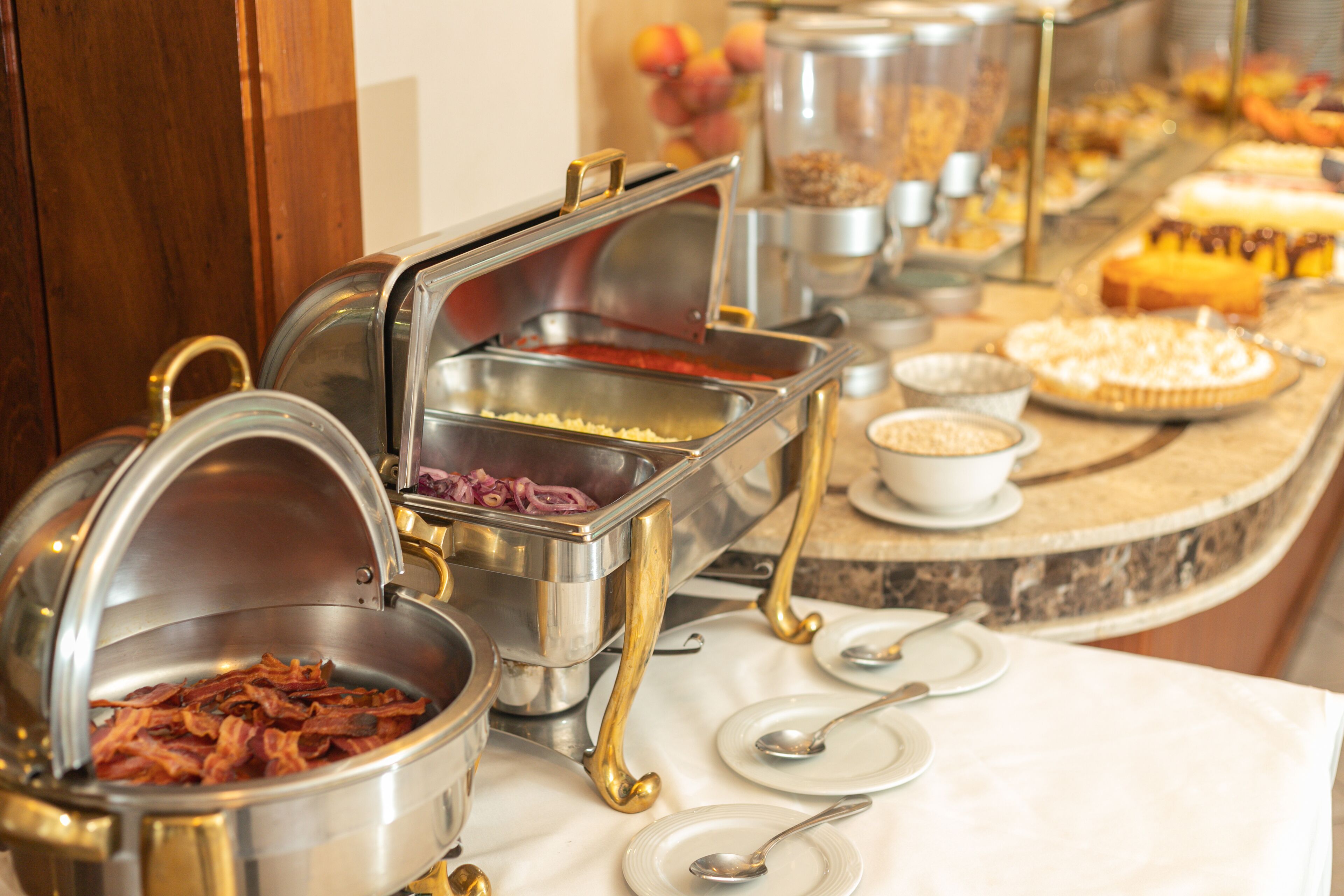 A buffet with various food items and utensils.