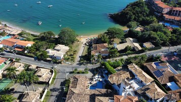 Vista aerea di una zona residenziale costiera con case, spiaggia e barche.