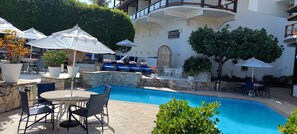 Relax by the serene pool surrounded by lush greenery and comfortable lounge chairs.