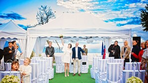 A tented wedding venue with a green carpet and white chairs. - Hotel Bellevue (Kranj)