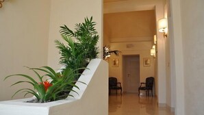 A hallway with a white wall, a staircase, and two chairs. - Il Mattino ha l'oro in bocca (Pisa)