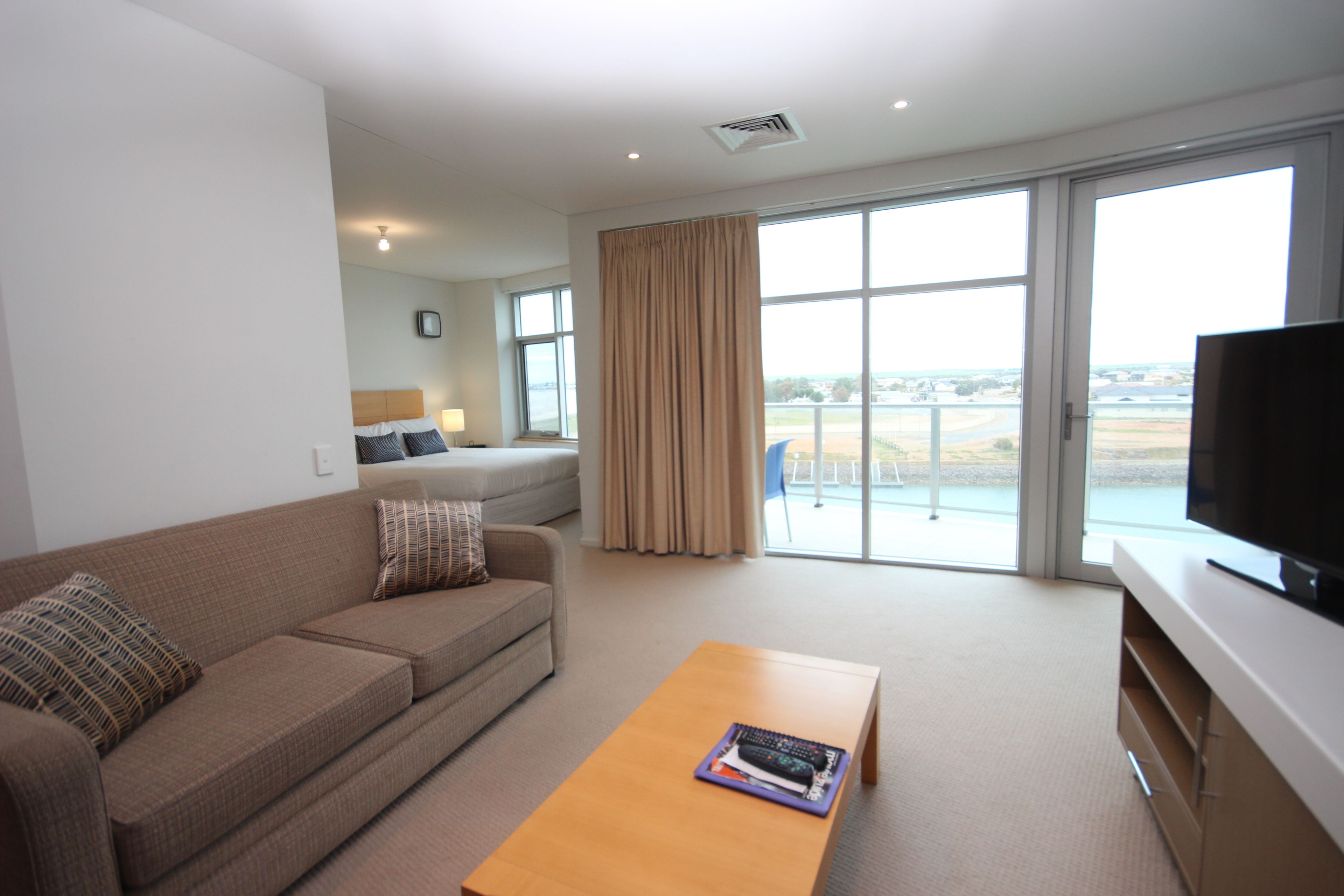 A modern living room with a sofa, a coffee table, and a television.