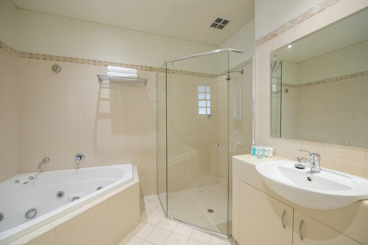 A bathroom with a bathtub, shower, and sink.