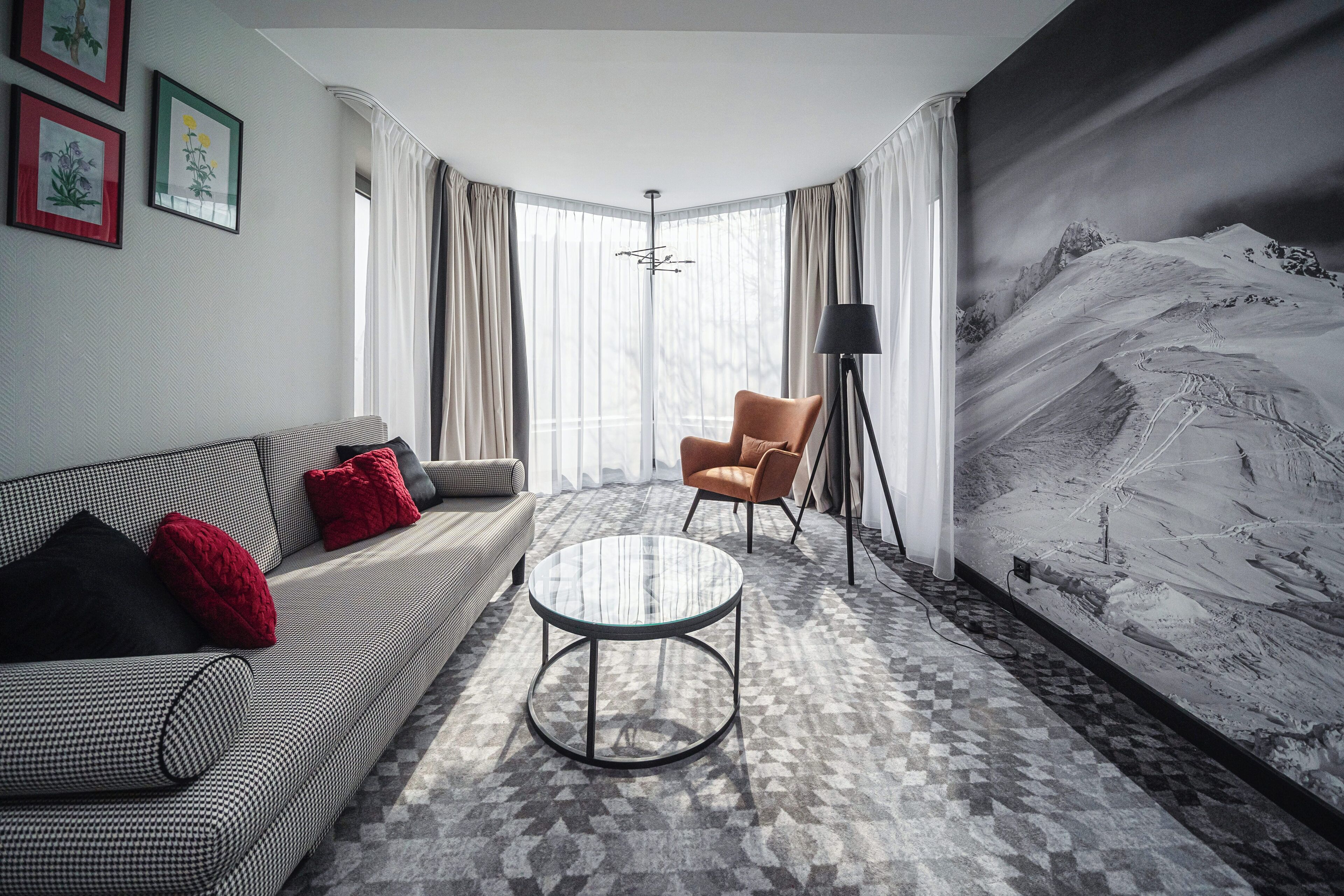 A modern living room with a sofa, armchair, and round coffee table.