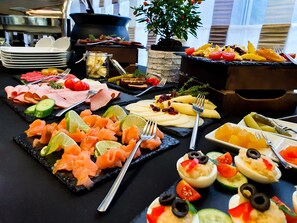 A buffet with various food items including salmon, cheese, and deviled eggs.