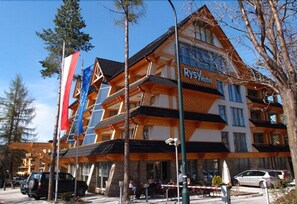 A multi-story hotel with a modern design, featuring a prominent 'Rys Hotel' sign.