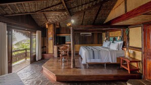 A spacious bedroom with a large bed, a wooden desk, and a television. - Dayo Hotel (Trairi)