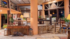 A spacious lobby with a stone floor, wooden furniture, and a high ceiling with exposed beams. - Dayo Hotel (Trairi)
