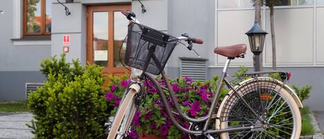 A bicycle parked in front of a building with a sign reading "Hotel Herman".