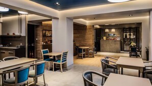 Un moderno vestíbulo de hotel con mostrador de recepción, zona de estar y bar.