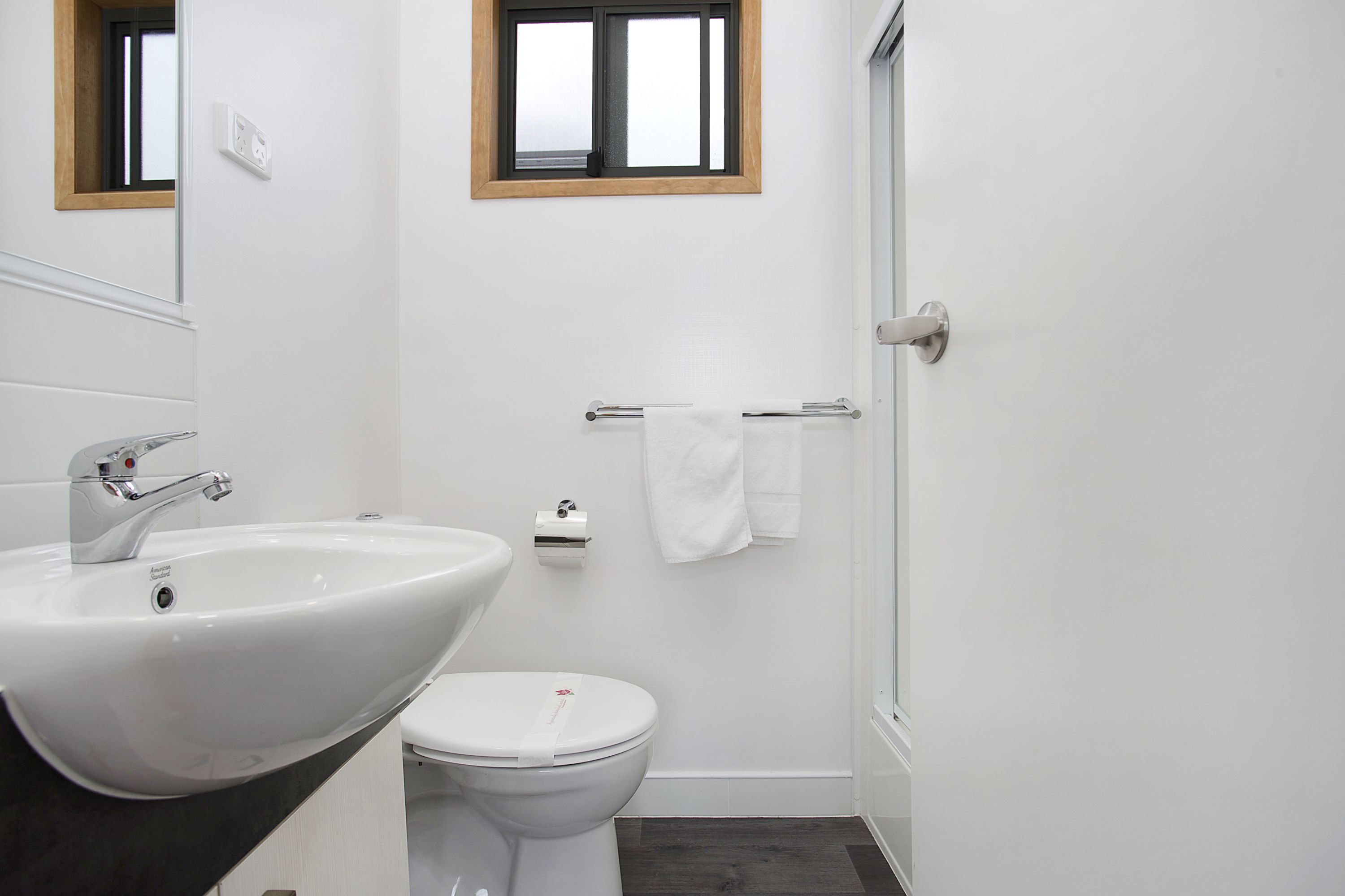 Une salle de bain avec un lavabo blanc, des toilettes et un porte-serviettes.