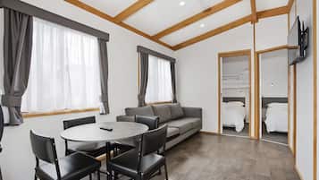 Cabaña Deluxe, 2 habitaciones | Área de sala de estar | Televisión LCD de 32 pulgadas con canales digitales y televisión