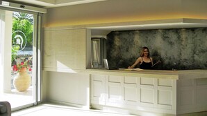 Un área de recepción con diseño moderno, un amplio ventanal y una mesa de recepción.