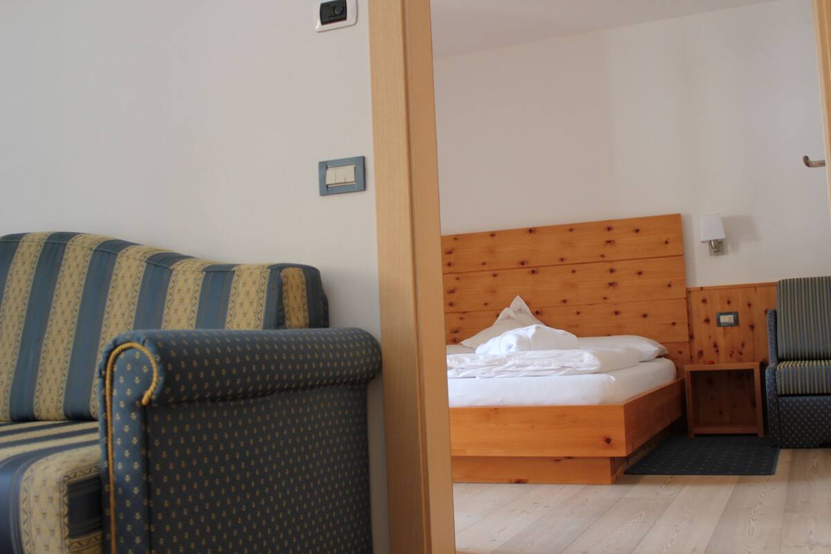 A room with a bed, a sofa, and a chair.