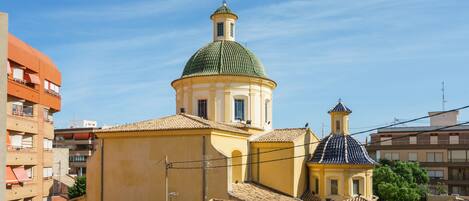 A historic building with a prominent dome and a smaller adjacent structure, surrounded by other buildings.