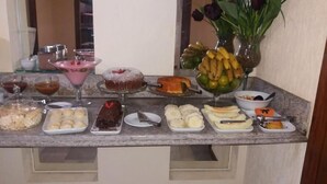A buffet table with various desserts and fruits. - Sakr Hotel (Penapolis)