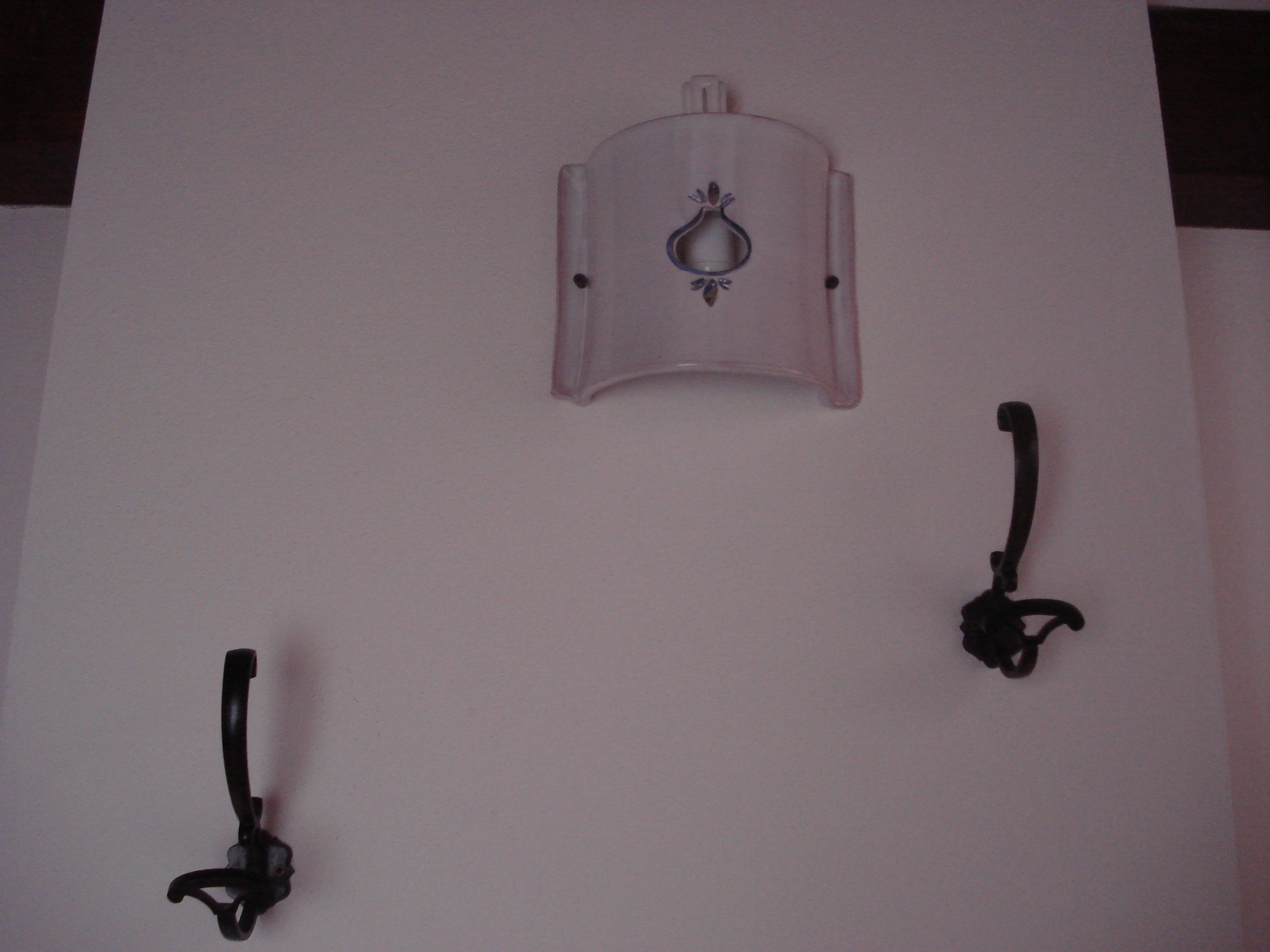Ein an der Wand befestigtes Objekt mit Griff und dekorativem Detail.
