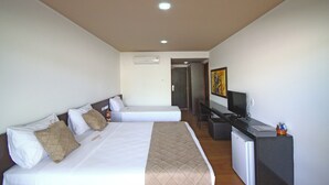 A hotel room with two beds, a desk, a television, and a refrigerator. - Fazenda Monte Castelo (Sairé)