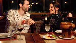 A couple dining at a restaurant with a view of the city at night. - Fazenda Monte Castelo (Sairé)