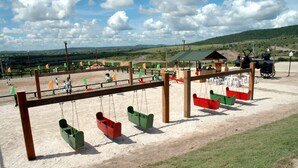 A playground with swings and a covered seating area. - Fazenda Monte Castelo (Sairé)