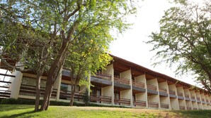 A multi-story building with balconies, surrounded by trees and grass. - Fazenda Monte Castelo (Sairé)