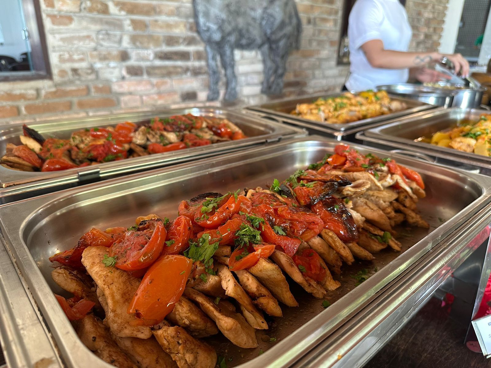 A buffet with various dishes, including grilled chicken and vegetables.