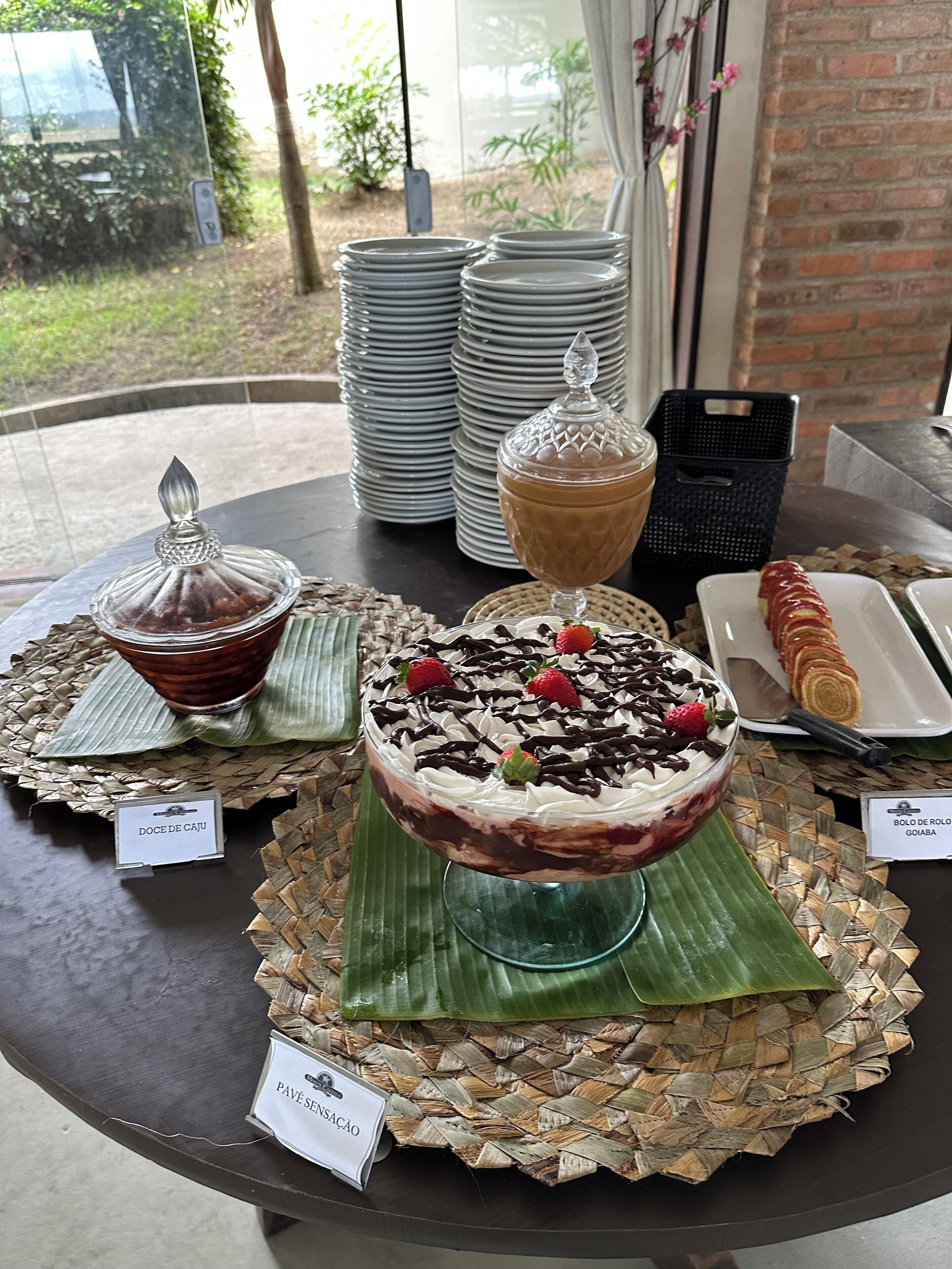 Une table où sont présentés divers desserts, notamment un dessert à plusieurs couches, un gâteau enrobé de chocolat et une pâtisserie.