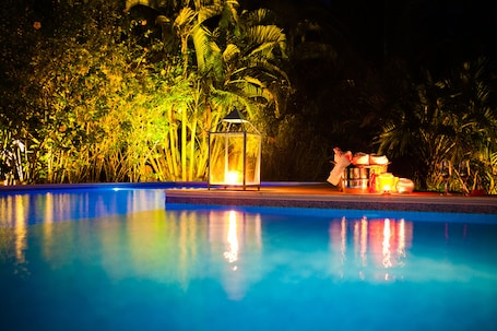 Una piscina al aire libre, sombrillas, sillones reclinables de piscina