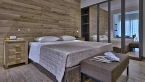 Un dormitorio moderno con pared de madera, una cama grande con cubrecama acolchado, una mesita de noche con lámpara y un espejo.