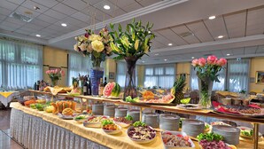 Una barra de buffet con diversos alimentos y centros de mesa florales.