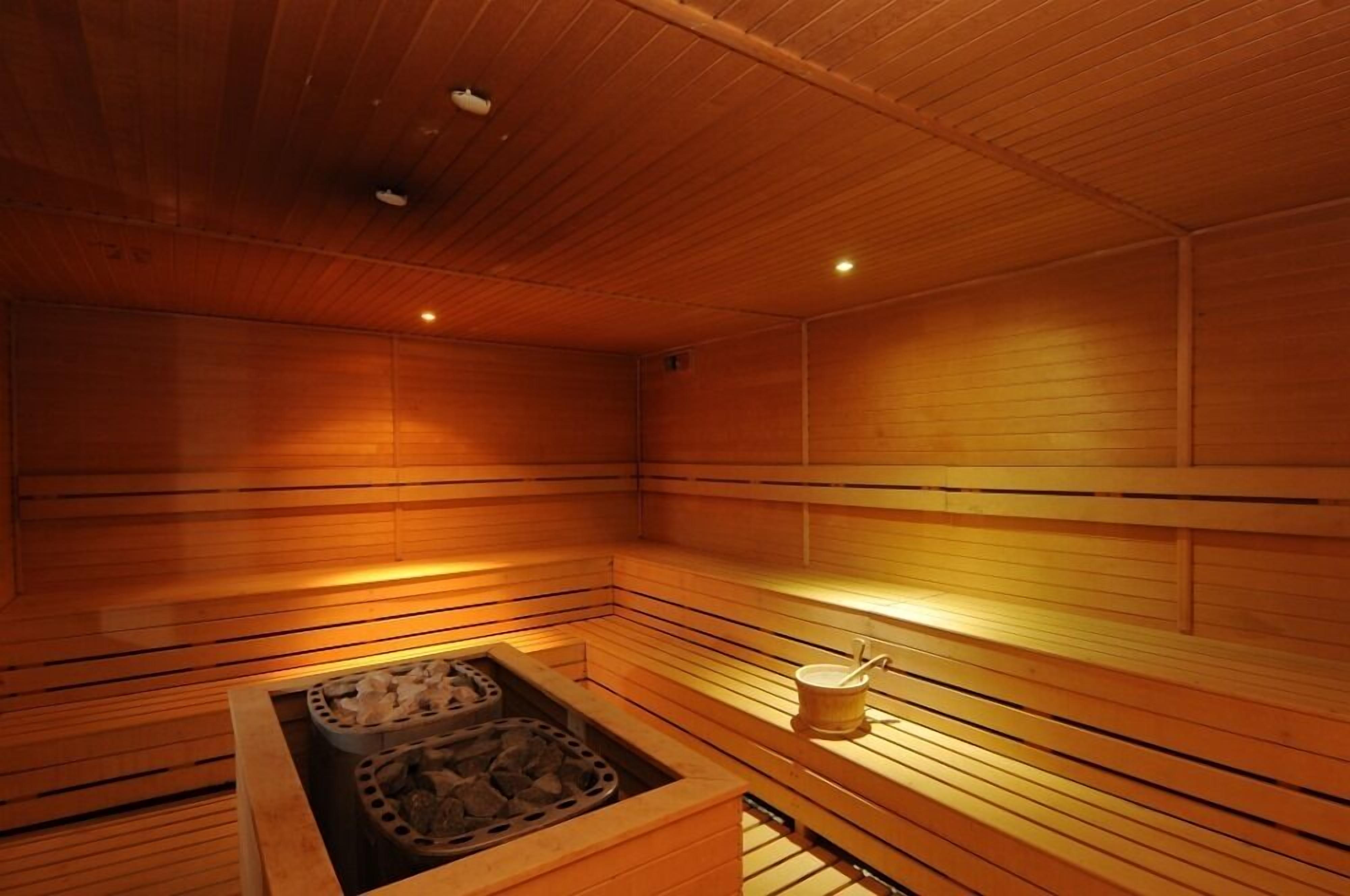 A wooden sauna with benches and a stone basin.
