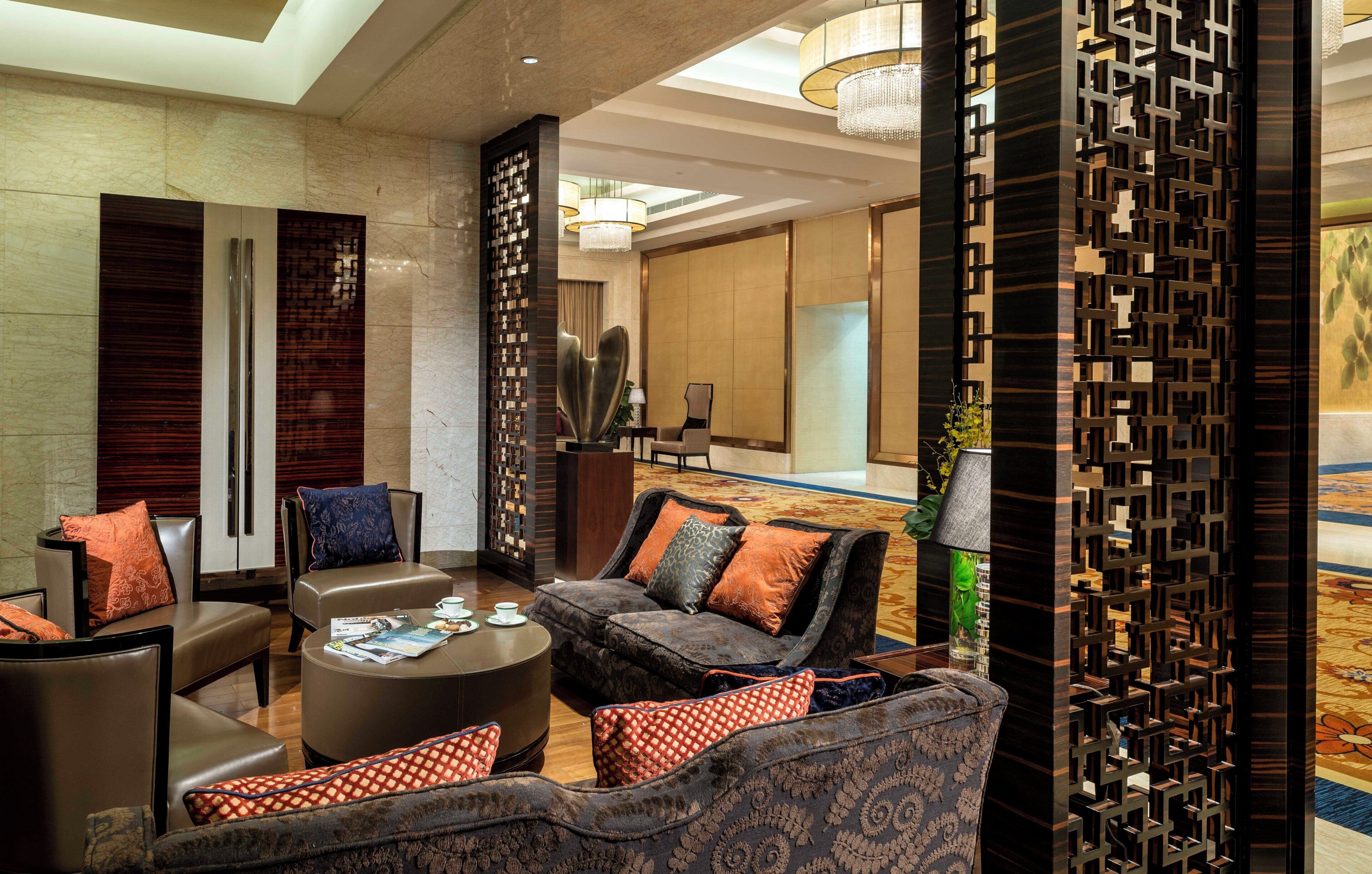 A modern lobby with leather seating, a round coffee table, and decorative panels.
