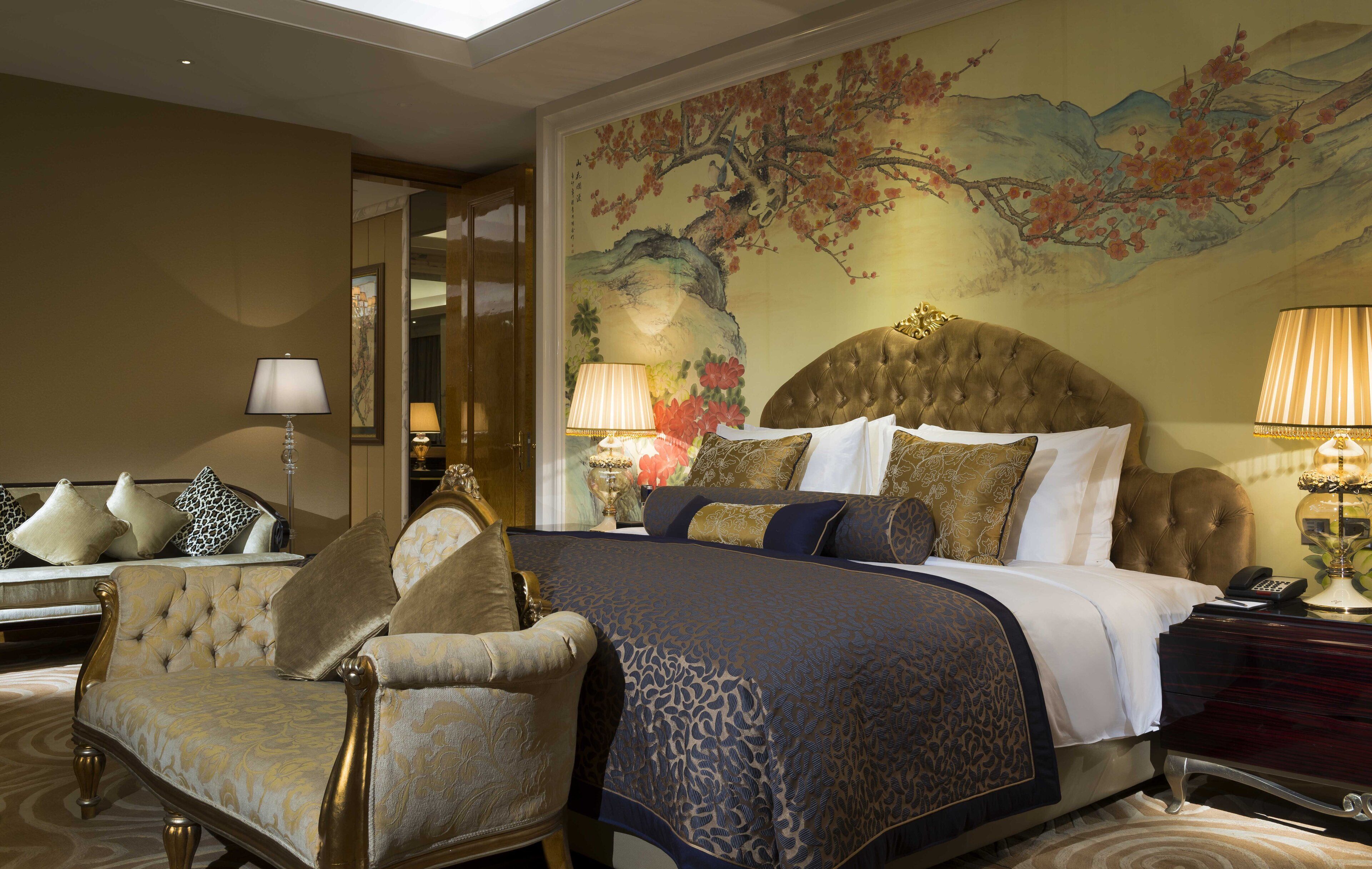 Um quarto luxuoso com uma cama grande, cabeceira ornamentada e um painel decorativo na parede.