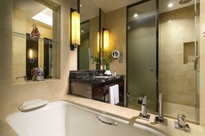A modern bathroom with a large bathtub, a glass-enclosed shower, and a vanity with a mirror. - Intercontinental Tangshan by IHG (Tangshan)